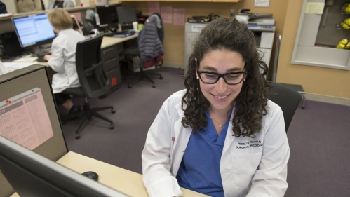 A surgical fellow works on a computer
