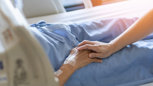 A person holds a patient's hand