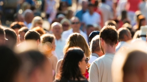 Crowds of people walk on a street