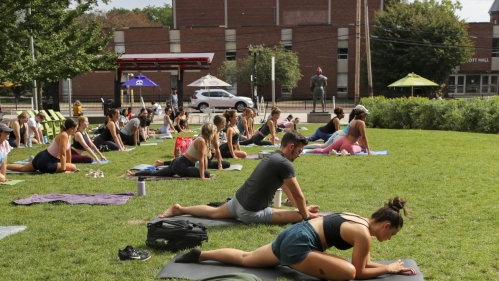 Students stretch on yoga mats in the Yard on the New Brunswick campus