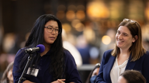 Participants speak at a microphone during the immigration summit in 2025