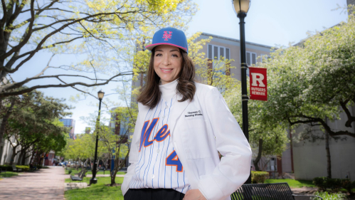 Theresa Coderi, who is getting her nursing degree this May, is wearing a N.Y. Mets baseball cap and jersey under her nurses coat