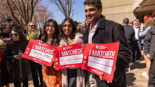 Robert Wood Johnson medical school students hold up signs identifying where they matched 