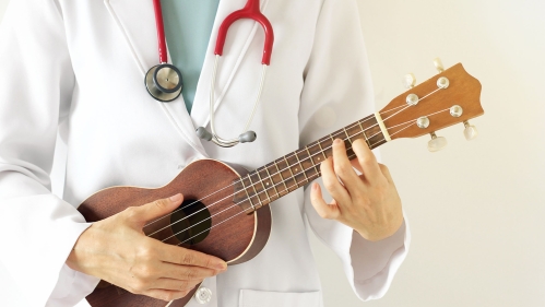 white-coated doc plays small guitar