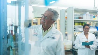 Asthma researcher Reynold Panettieri writes on a board in a lab.