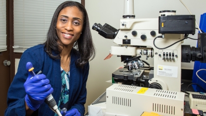 A researcher at NJMS works in a lab