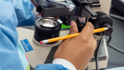 A student looks into a microscope