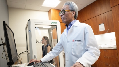 A researcher conducts a breathing test with a patient in the clinical research center