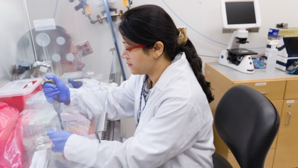 A researcher works at a hood station in a Rutgers lab
