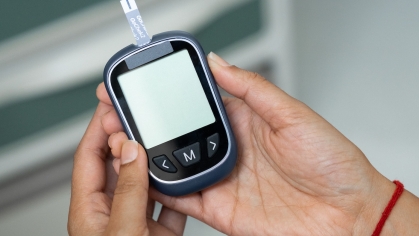 A researcher holds a device used to test blood samples.