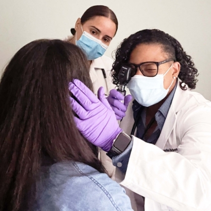 A clinician examines a patient's eyes in a clinic