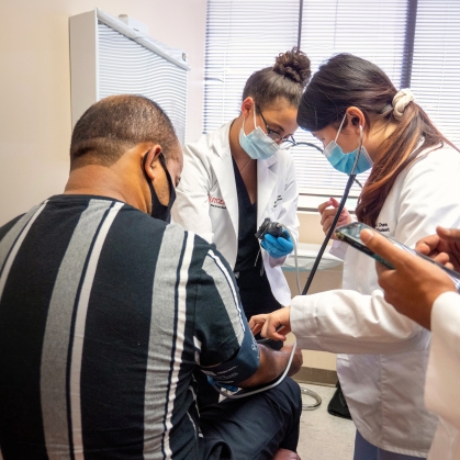 Medical students examine a patient in a clinic in Newark