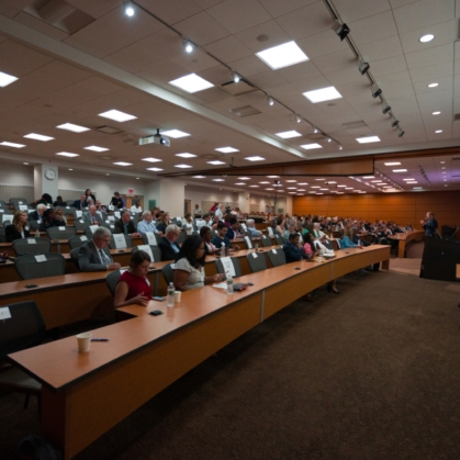 Participants listen to a presentation in a lecture hall during the Integration Summit 