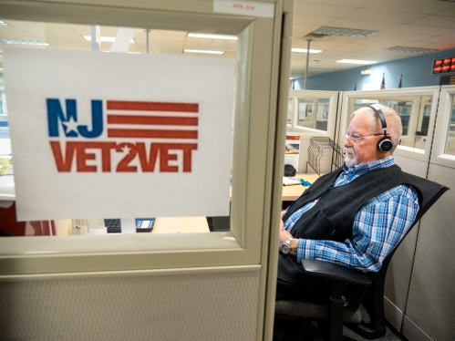 An employee at UBHC sits in a cubical with a telephone headset on