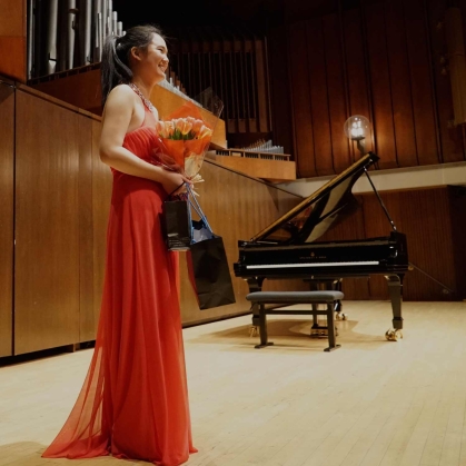 Angela Zhao stands before an audience during her Juilliard pre-college graduation recital.
