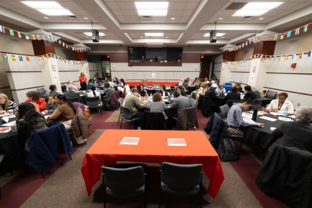 Attendees talk in groups at tables during the integration summit.