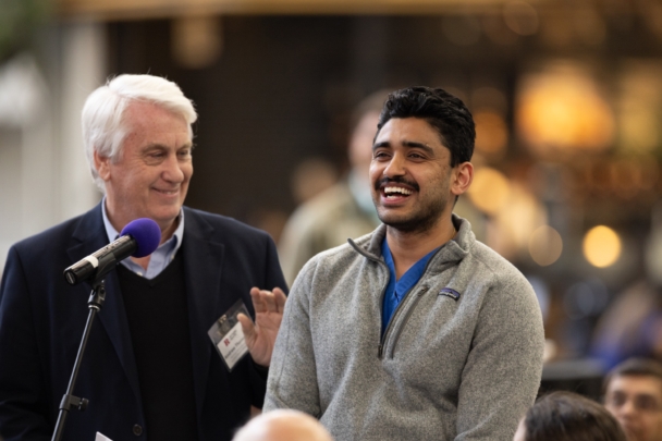A student and faculty member stand at a microphone during the integration meeting at RWJMS 