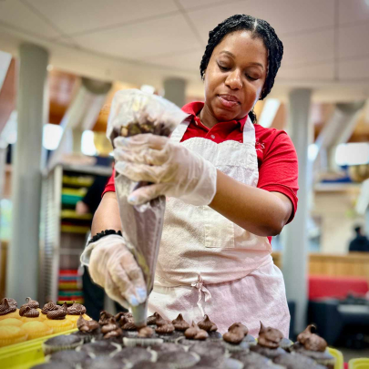 A Rutgers employee adds frosting to cupcakes during Rutgers Day on Busch campus.