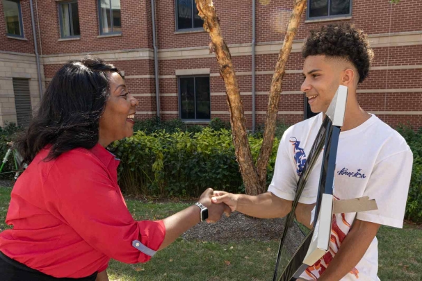 Rutgers-New Brunswick Chancellor Francine Conway (left) greets a student outside of BEST Hall.